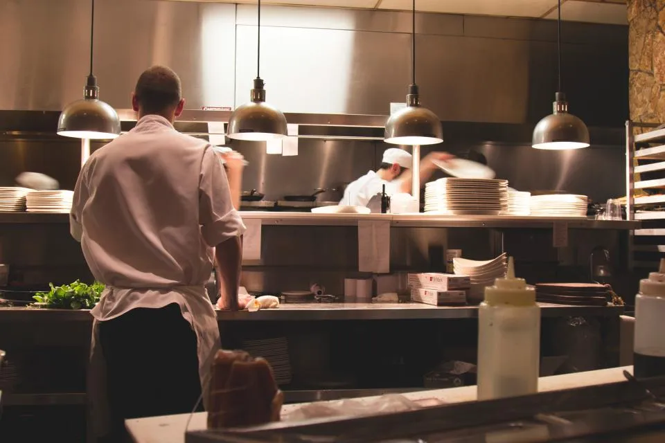 Chefs at work along the pass of a busy restaurant kitchen